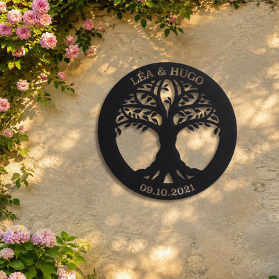 Jeune arbre – plaque en acier personnalisée « Léa & Hugo · 09.10.2021 » sur un mur de jardin – Steelmonks