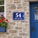 Plaque de maison style émaillé bleu, sur une façade en pierre · Steelmonks