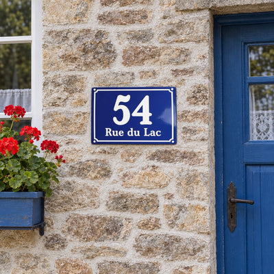 Plaque de maison style émaillé bleu, sur une façade en pierre · Steelmonks