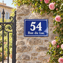 Plaque de maison style émaillé bleu, sur un mur de jardin · Steelmonks