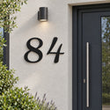 Numéro de maison personnalisé – design Courbé, acier découpé au laser, à côté de la porte d'entrée · Steelmonks