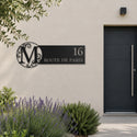 Plaque de rue avec monogramme personnalisée, acier découpé au laser, à côté de la porte d'entrée · Steelmonks