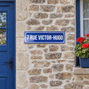 Plaque de rue style émaillé bleu façon Paris, sur une façade en pierre · Steelmonks