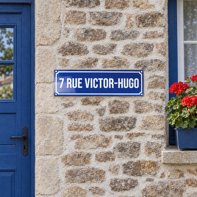 Plaque de rue style émaillé bleu façon Paris, sur une façade en pierre · Steelmonks