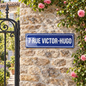 Plaque de rue style émaillé bleu façon Paris, sur un mur de jardin · Steelmonks