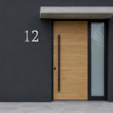 Numéro de maison Intemporel en inox sur une façade sombre